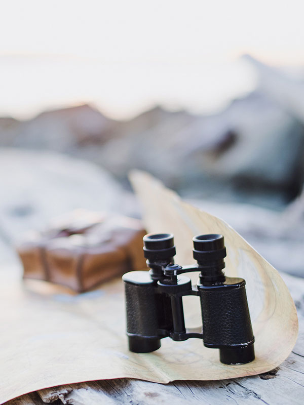 Traveler looking at a map and binoculars